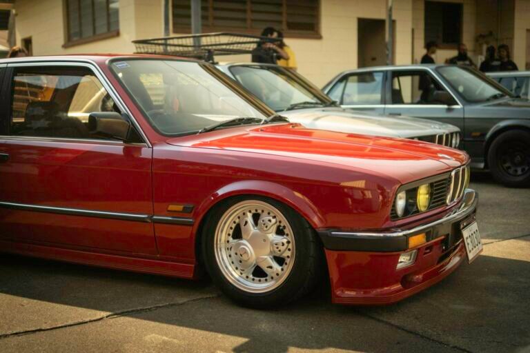 Classic BMW E30 coupe showcased at a Brisbane car event, featuring vintage design and euro car enthusiasts.