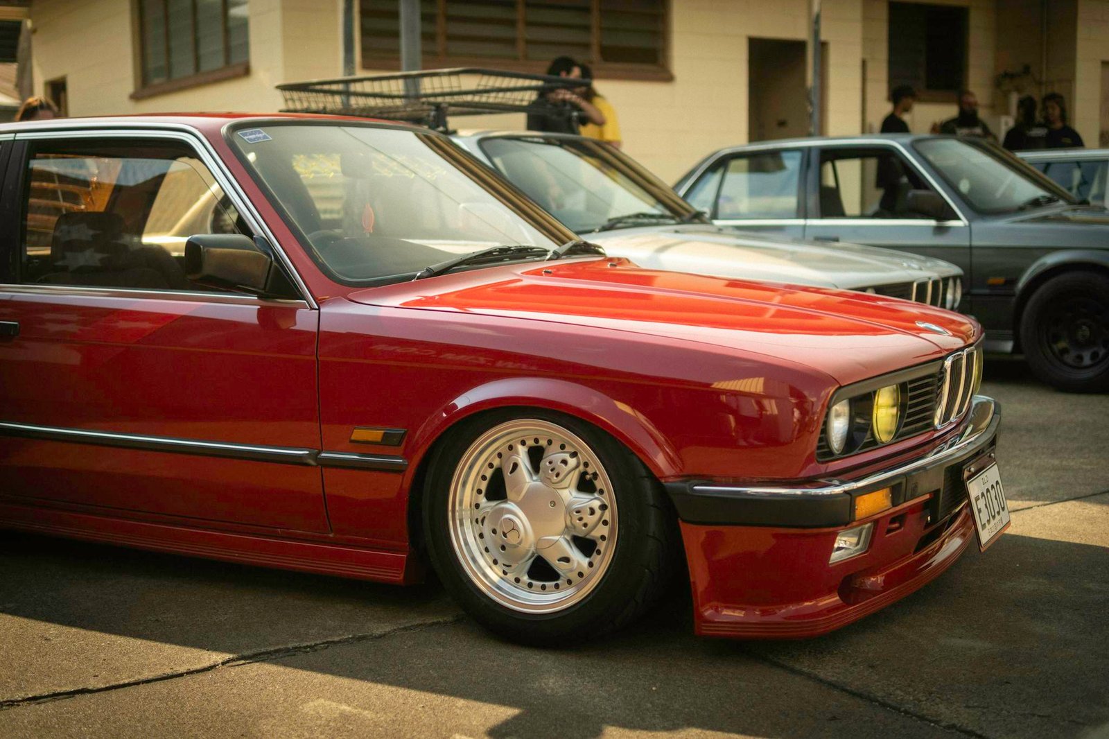 Classic BMW E30 coupe showcased at a Brisbane car event, featuring vintage design and euro car enthusiasts.